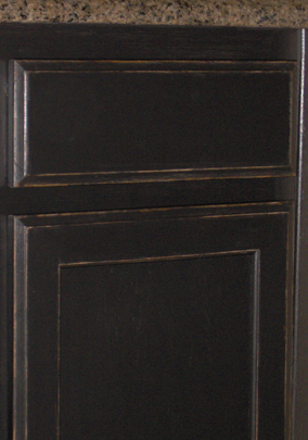 Detail of Kitchen Cabinets painted satin black then antiqued and distressed.